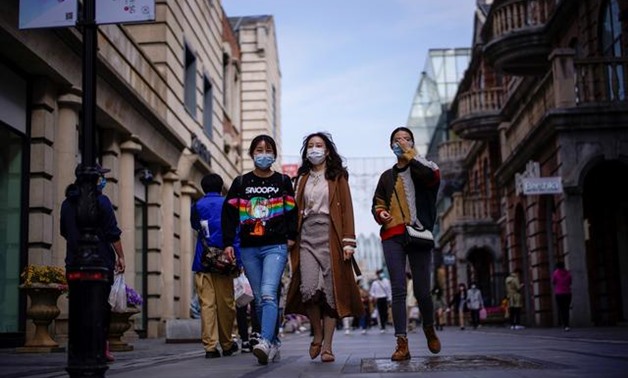 FILE PHOTO: People wearing face masks are seen at a main shopping area after the lockdown was lifted in Wuhan, capital of Hubei province and China's epicentre of the novel coronavirus disease (COVID-19) outbreak, April 14, 2020. REUTERS/Aly Song
