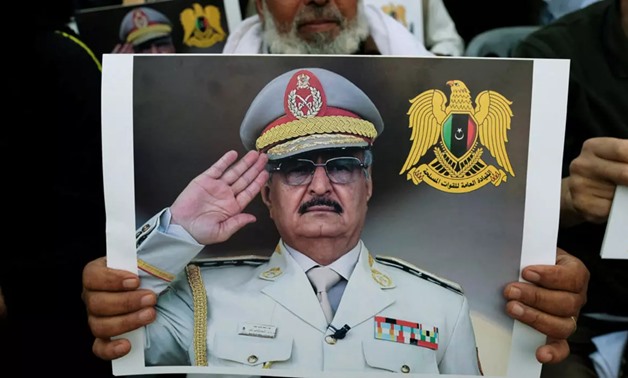 A Libyan man carries a picture of Khalifa Haftar during a demonstration to support Libyan National Army offensive against Tripoli, in Benghazi, Libya April 12, 2019. (Reuters)
