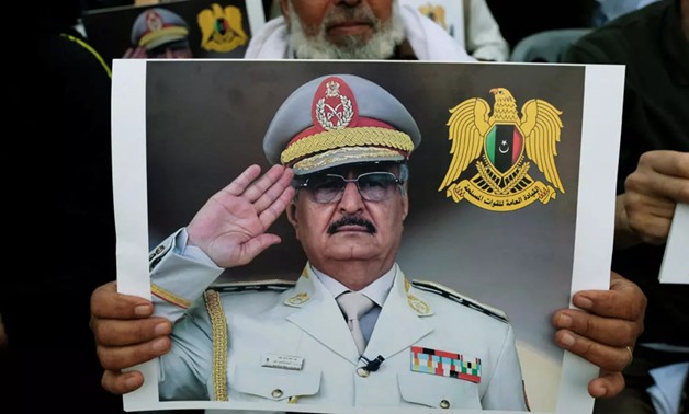 A Libyan man carries a picture of Khalifa Haftar during a demonstration to support Libyan National Army offensive against Tripoli, in Benghazi, Libya April 12, 2019. (Reuters)
