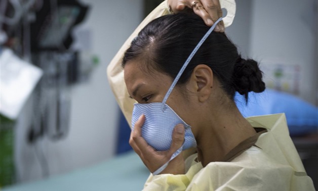 U.S. Navy Lt. Gail Evangelista, nurse, assigned to Naval Hospital Rota, Spain, dons a facemask prior to interacting with a patient at the Michaud Expeditionary Medical Facility (EMF) at Camp Lemonnier, Djibouti, April 16, 2020. Evangelista is part of a fo