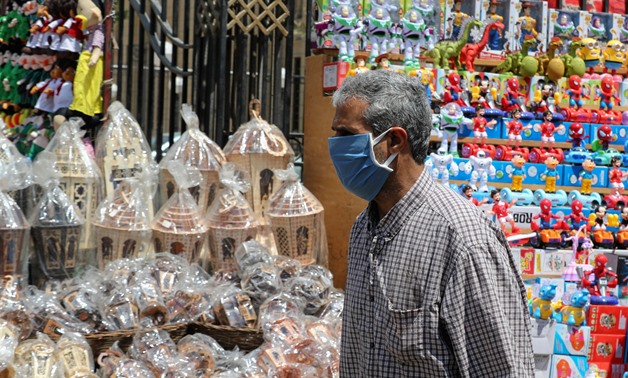 A man wearing a protective face mask, amid concerns over the coronavirus disease (COVID-19) buys traditional Ramadan lanterns, called "Fanous" which are displayed for sale at a stall, ahead of the Muslim holy month of Ramadan in Cairo, Egypt, April 12, 20