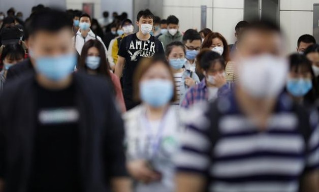 People wearing face masks walk inside a subway station during morning rush hour, following an outbreak of the coronavirus disease (COVID-19), in Beijing, China May 11, 2020. REUTERS/Carlos Garcia Rawlins