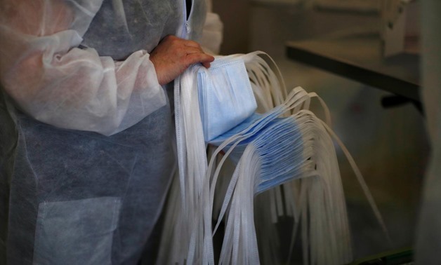 An employee inspects health protection masks at the Kolmi-Hopen company's factory in Saint-Barthelemy-d'Anjou as their activities boosted following the coronavirus outbreak, France, February 5, 2020. Picture taken February 5, 2020. REUTERS/Stephane Mahe
