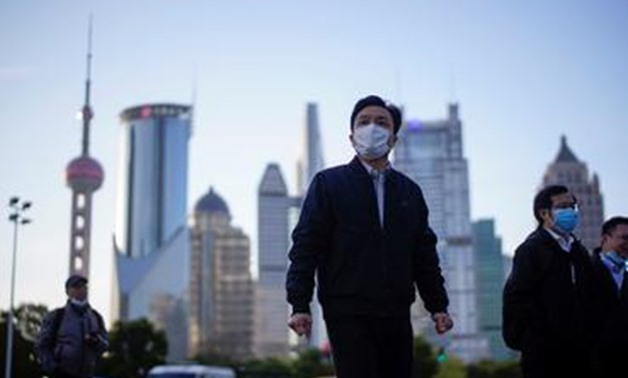 FILE PHOTO: FILE PHOTO: People wear protective face masks, following an outbreak of the novel coronavirus disease (COVID-19), at Lujiazui financial district in Shanghai, China March 19, 2020. REUTERS/Aly Song - RC22NF9MD3D3/File Photo/File Photo
