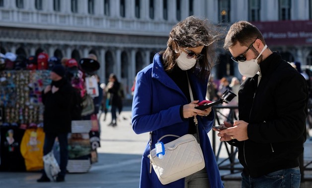 Tourists wear protective masks in Saint Mark's Square in Venice as Italy battles a coronavirus outbreak, Venice, Italy, February 27, 2020. REUTERS/Manuel Silvestri
