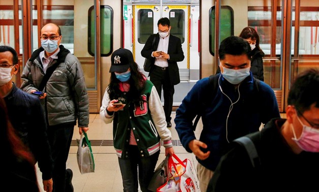 FILE PHOTO: People wear protective masks following the outbreak of a new coronavirus, during their morning commute in a station, in Hong Kong, China February 10, 2020. REUTERS/Tyrone Siu/File Photo