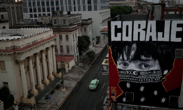 Cuban artist "Mr Myl" paints a mural which reads in Spanish: "Courage", amid concerns about the spread of the coronavirus disease (COVID-19) outbreak, in downtown Havana, Cuba, May 20, 2020. REUTERS/Alexandre Meneghini
