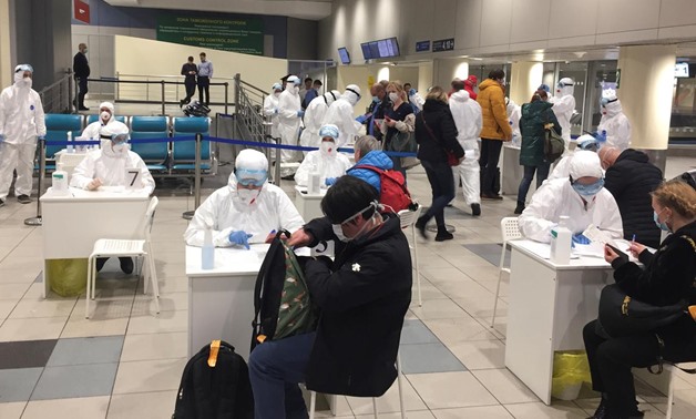 Russian officials and medical staff wearing protective gear check passengers as a preventive measure against the coronavirus (COVID-19) at Moscow's Domodedovo Airport, Russia March 7, 2020. Picture taken March 7, 2020. REUTERS/Stringer
