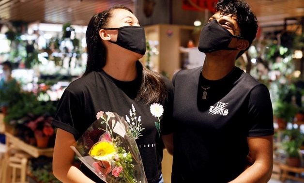 Couple Tareesh 20 and Phebe 16, share a laugh after they are reunited after weeks of ciruit breaker lockdown in Singapore as the city state reopens the economy amid the coronavirus disease (COVID-19) outbreak, June 19, 2020. REUTERS/Edgar Su
