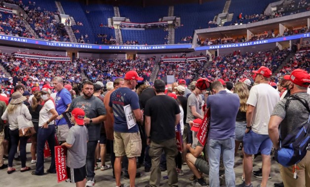 FILE PHOTO: Supporters of U.S. President Donald Trump wait for him to appear onstage 27 minutes before the scheduled start of his speech June 20, 2020. REUTERS/Leah Millis