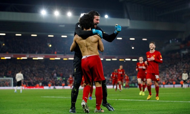 Liverpool's Mohamed Salah celebrates scoring their second goal with Alisson. -Reuters
