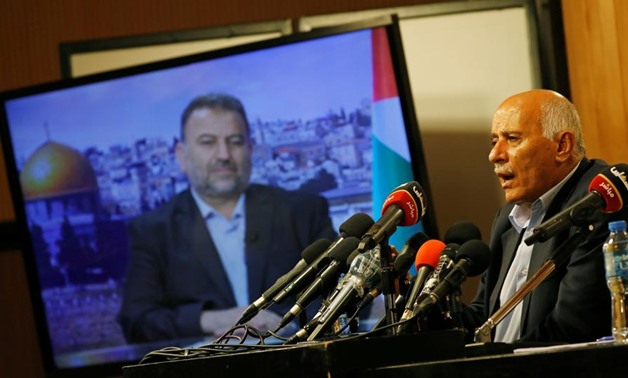 Senior Fatah official Jibril Rajoub speaks as deputy Hamas chief Saleh Arouri appears on a TV screen during a video conference, Ramallah, July 2, 2020. (Reuters)