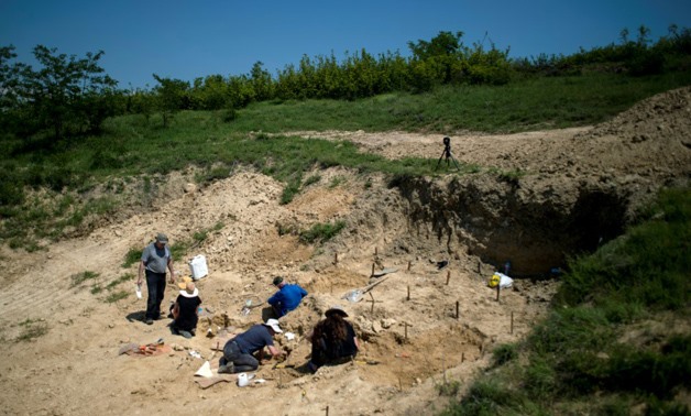 Palaeontologists work near the site in Bulgaria where a fossilised tooth with three roots was found, which some researchers say may be a sign of the oldest known human ancestor - AFP / NIKOLAY DOYCHINOV