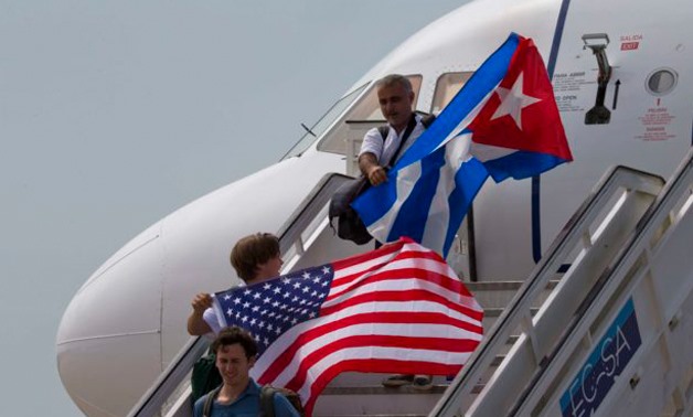 Two passengers deplane from JetBlue flight 387 waving a United States, and Cuban national flag, in Santa Clara. As President Donald Trump vows a reversal on the US Cuba policy on Friday, June 16, 2017, Cubans are bracing for the worst. Across the island, 