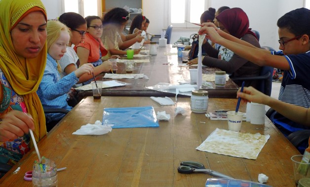 Children learning papyrus production procedures-File Photo