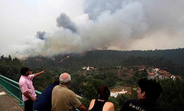 People look at fire and smoke during a forest fire in Pedrogao Grande, in central Portugal, June 18, 2017. REUTERS/Miguel Vidal