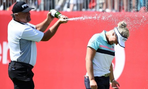 Brooke Henderson of Canada is sprayed with champagne by her father Dave Henderson after winning the Meijer LPGA Classic at Blythefield Country Club on June 18, 2017 in Grand Rapids, Michigan – GETTY/AFP

