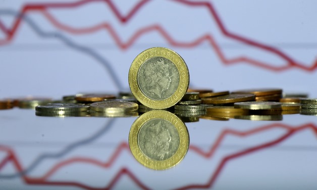 Pound coins are seen in front of displayed stock graph in this picture illustration taken June 9, 2017. REUTERS/Dado Ruvic/Illustration