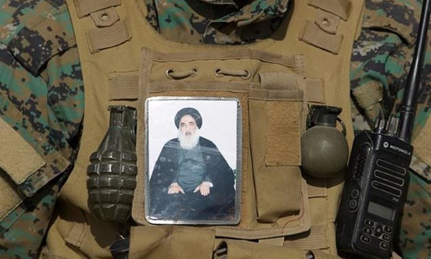 An Iraqi Shiite fighter is seen with an image of Ayatollah Ali al-Sistani on his vest during an offensive to retake Mosul from the Islamic State group - AFP