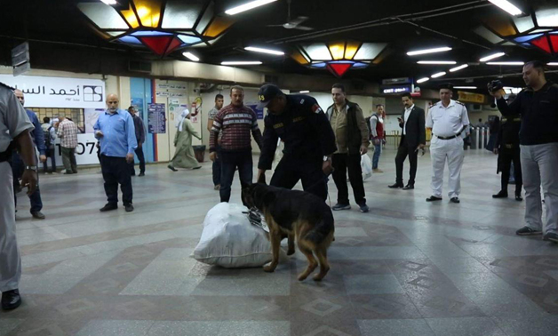 Police officers with guard dogs inspects commuters' bags at a metro station- press photo