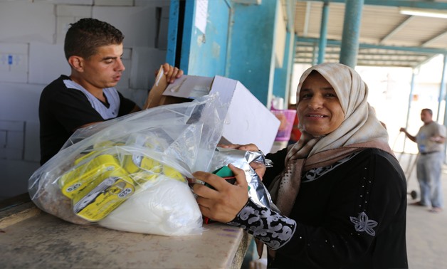 A Palestine refugee woman receives food assistance at the UNRWA Khan Younis Distribution Centre in Gaza