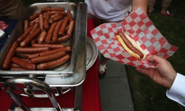 Hotdogs are handed out during the annual Capitol Hill Hot Dog Lunch at the courtyard of Rayburn House Office Building July 23, 2014, on Capitol Hill in Washington, DC. A competitive eater, Joey ‘Jaws’ Chestnut, downed 72 hot dogs in 10 minutes at the annu