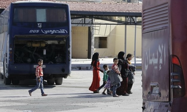 Displaced Syrians who fled with their families Islamic State controlled areas in Raqa, Deir Ezzor and Mayadeen gather at Aleppo's bus station of Ramussa on July 4, 2017. Syrian escapees from the Islamic State group languished for hours on the sizzling con
