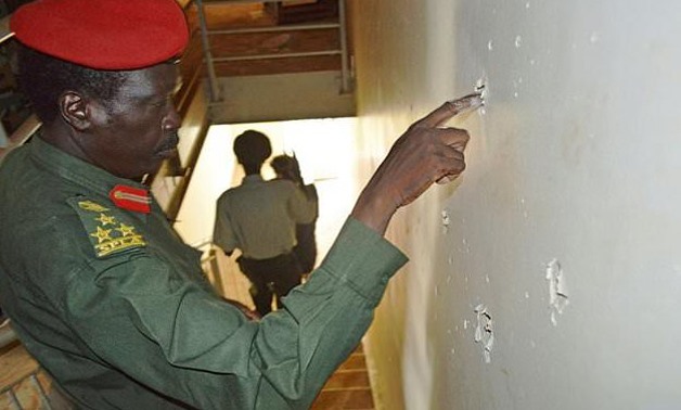 Brigadier General Knight Barino, President of the SPLA military court examines bullets holes in the wall of the Terrain Hotel, in Juba on July 3, 2017 - AFP
