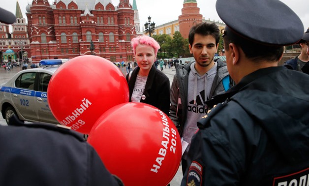 Supporters of Russian opposition leader Alexei Navalny hold balloons as they speak to police near the Kremlin in Moscow, on July 8, 2017, a day after Navalny was released from 25 days in jail for organising unauthorised protests. The 41-year-old Kremlin c