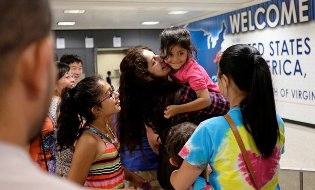 Sana Tahir holds Malaika Noman, 3, as the child enters the U.S. after a judge ruled that President Trump's temporary ban on travelers from six Muslim-majority countries cannot stop grandparents and other relatives of U.S. citizens from entering - Reuters