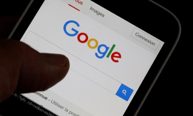 A man holds his smartphone which displays the Google home page, in this picture illustration taken in Bordeaux, Southwestern France, August 22, 2016 - Reuters