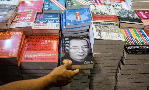 A visitor looks at a biography of the late Chinese Noble laureate Liu Xiaobo at the International Book Fair in Hong Kong on July 20, 2017 (AFP Photo/Isaac Lawrence)
