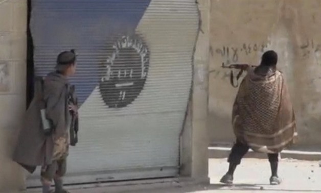 A still image taken from a video posted to a social media website by the Islamic State-affiliated Amaq News Agency, on July 15, 2017, shows a man appearing to be an Islamic State militant firing a weapon, said to be in Raqqa - Reuters
