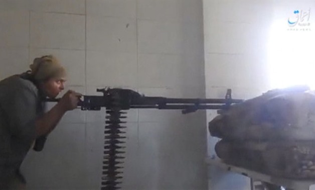 A still image taken from a video posted to a social media website by the Islamic State-affiliated Amaq News Agency, on July 15, 2017, shows a man appearing to be an Islamic State militant firing a weapon, said to be in Raqqa - REUTERS