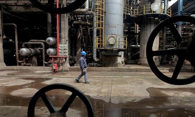 A worker walks past oil pipes at a refinery in Wuhan, Hubei province- Reuters
