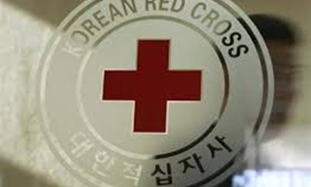 A man walks past a logo of the South Korean Red Cross at its headquarters in Seoul February 9, 2011 - REUTERS