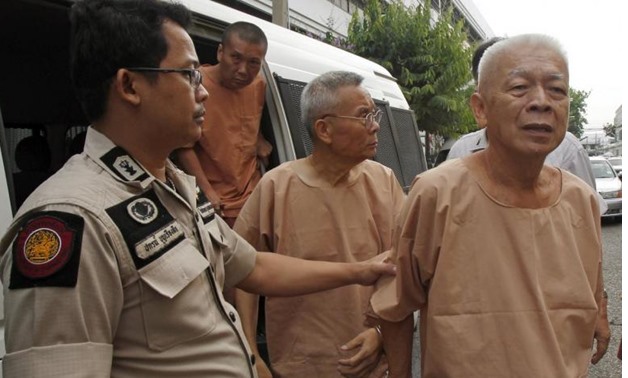Opas Charnsuksai (R), 67, is escorted by prison officers as they arrive at the military court in Bangkok March 20, 2015 - REUTERS