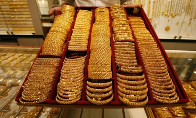 A salesman displays a tray of gold bangles for the camera at a jewellery shop in Singapore October 7, 2009. REUTERS-Vivek Prakash