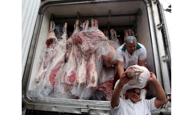 Workers unload packed meat from a truck - Reuters/ Paulo Whitaker