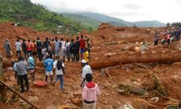 Residents stand as rescue workers search for survivors after a mudslide in the mountain town of Regent, Sierra Leone August 14, 2017.
