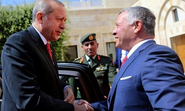 Jordan's King Abdullah II (R) greets Turkish President Recep Tayyip Erdogan at the royal palace in Amman