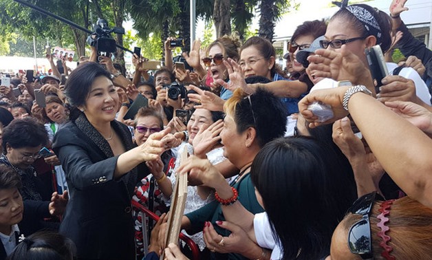 Ousted former Thai prime minister Yingluck Shinawatra greets supporters as she leaves the Supreme Court in Bangkok - REUTERS