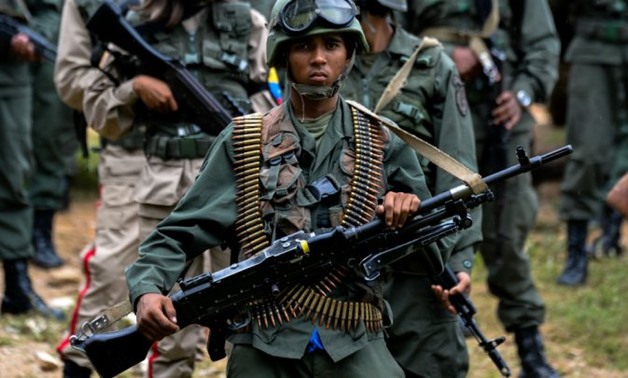 © Federico Parra / AFP | A Venezuelan army soldier carrying a squad machine gun (GPMG) attends the press conference given by Defence Minister general Vladimir Padrino Lopez at Fort Tiuna in Caracas on August 14, 2017.