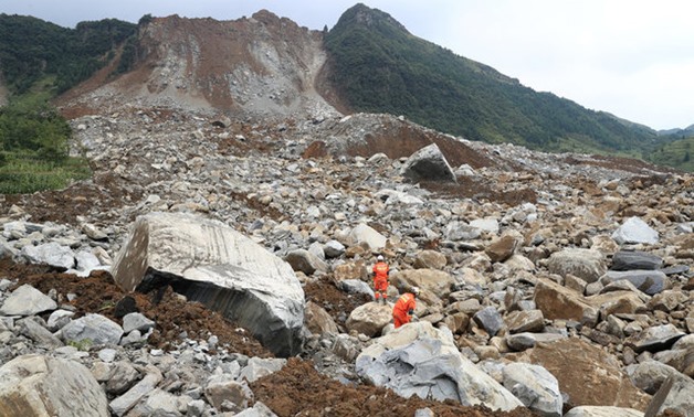 Rescue workers search for survivors at the site of a landslide that occurred in Nayong county - REUTERS