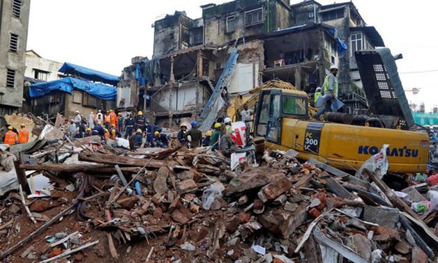 Firefighters and rescue workers search for survivors at the site of a collapsed building in Mumbai - REUTERS