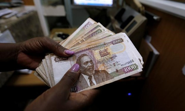 A teller counts Kenya shilling notes inside the cashier's booth at a forex exchange bureau in Kenya's capital Nairobi, April 20, 2016. REUTERS/Thomas Mukoya