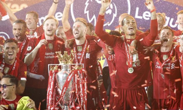 Liverpool's Jordan Henderson with teammates celebrates with the trophy after winning the Premier League Pool via REUTERS/Phil Noble
