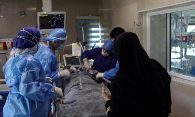 Nurses wearing protective suits, prepare a patient with coronavirus to be transferred to Masih Daneshvari Hospital in Tehran - Reuters