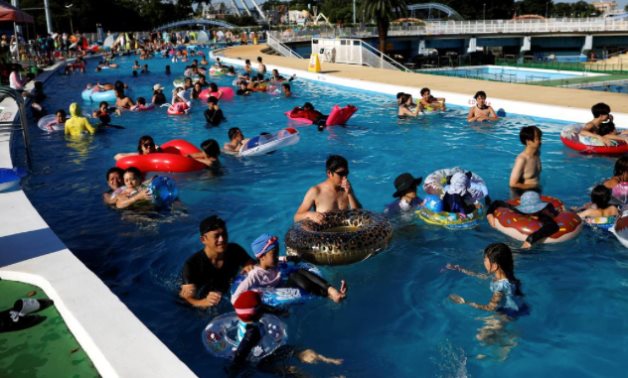 Visitors enjoy doughnut-shaped pool, amid the coronavirus disease (COVID-19) outbreak, at Toshimaen amusement park - REUTERS/Issei Kato