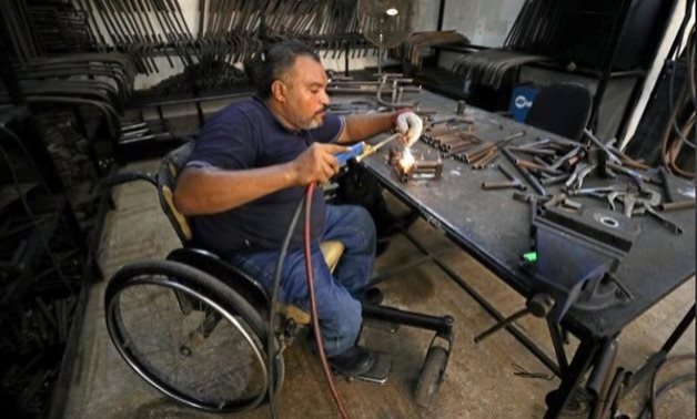 A disabled Egyptian man works in a workshop those manufactures products for the disabled in Cairo, Egypt 2017 - Reuters